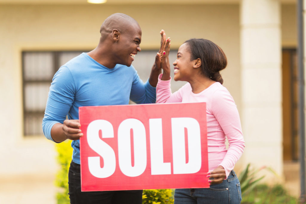 Couple holding a sold sign