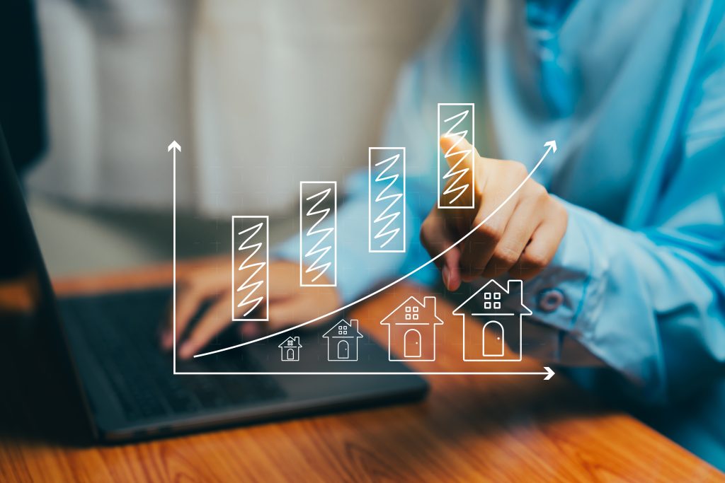 Raleigh NC real estate market growth chart, upward trending bar graph with house icons showing rising home values, person analyzing housing market statistics and data on laptop, Linda Craft Team REALTORS