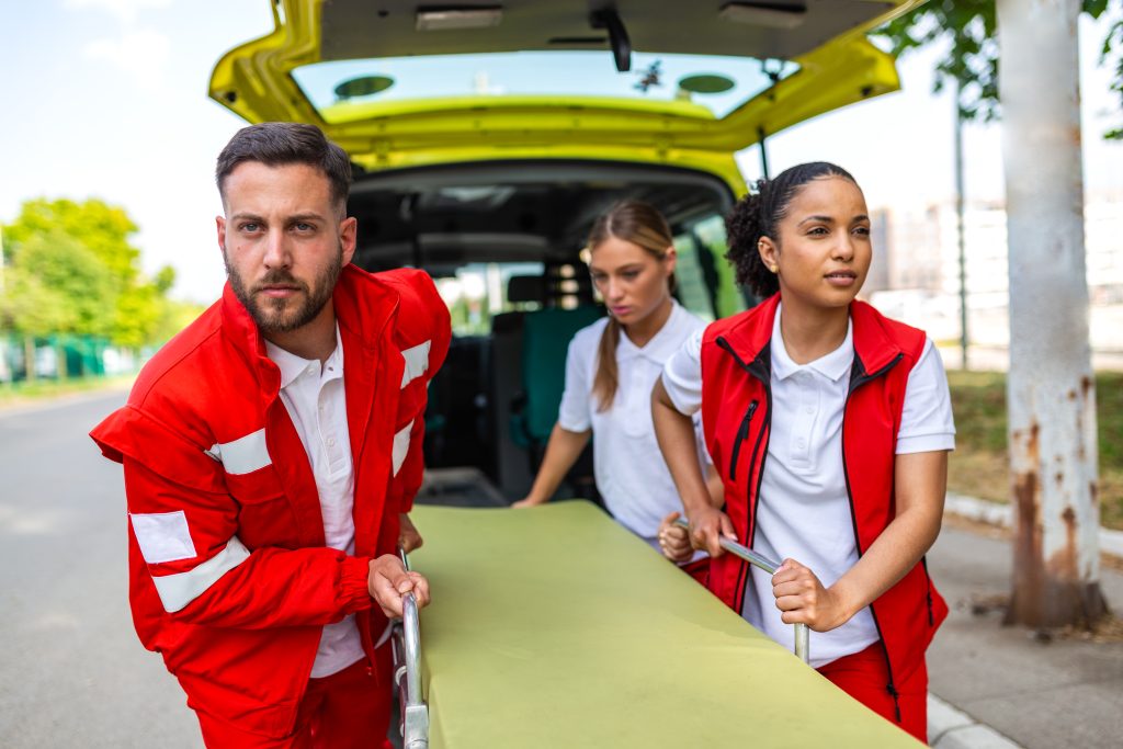 Red Cross responders wheeling a stretcher toward an ambulance, American Red Cross blood drive, Linda Craft Team
